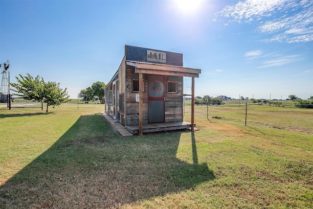 view of outdoor structure featuring a rural view and a yard