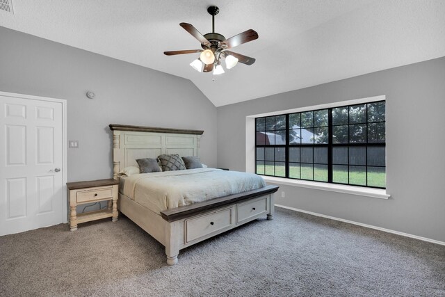 carpeted bedroom with ceiling fan, visible vents, baseboards, and vaulted ceiling