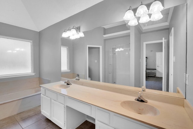 bathroom with a shower stall, double vanity, a sink, and tile patterned floors