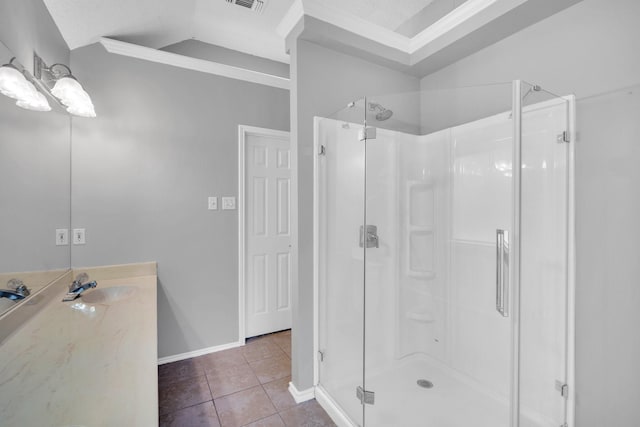 full bathroom featuring tile patterned flooring, vanity, visible vents, vaulted ceiling, and a shower stall