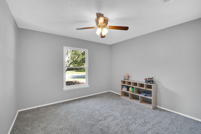 unfurnished room featuring carpet flooring, ceiling fan, a textured ceiling, and baseboards