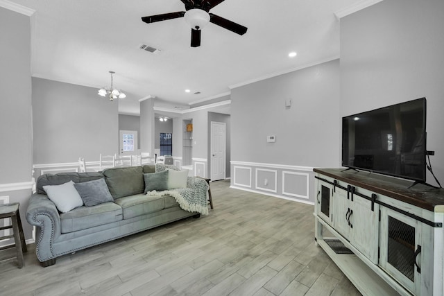 living room with light wood finished floors, visible vents, a decorative wall, and crown molding