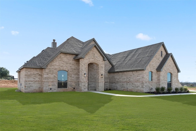 french country style house featuring a front lawn