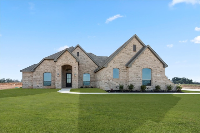 french country inspired facade featuring a front lawn