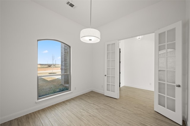 spare room with light wood-type flooring and french doors