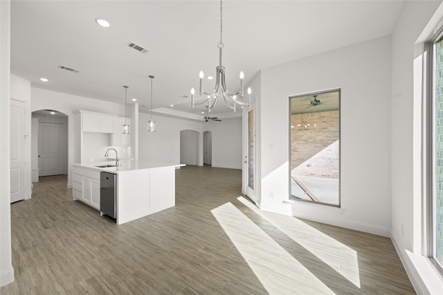 kitchen with white cabinets, an inviting chandelier, an island with sink, sink, and hanging light fixtures