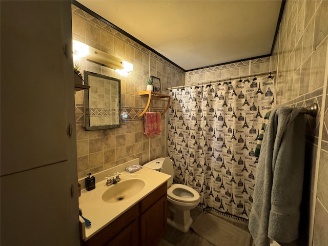 bathroom with tile walls, vanity, and toilet