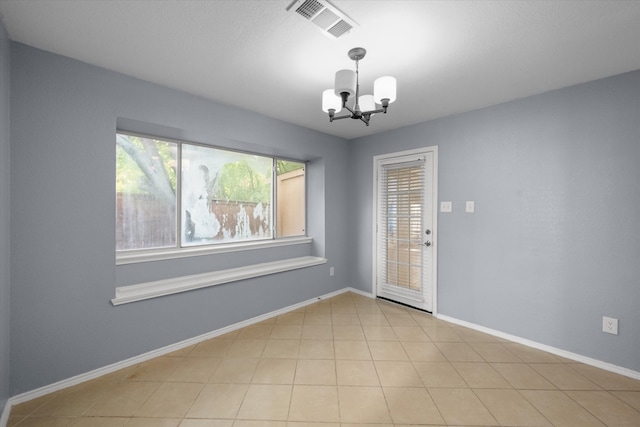 unfurnished room featuring light tile patterned floors and an inviting chandelier