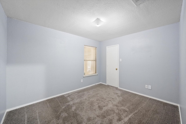 carpeted empty room featuring a textured ceiling