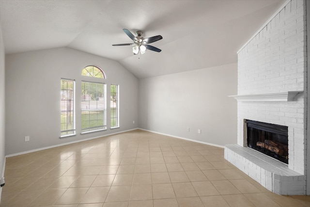 unfurnished living room featuring light tile patterned floors, a brick fireplace, ceiling fan, vaulted ceiling, and brick wall