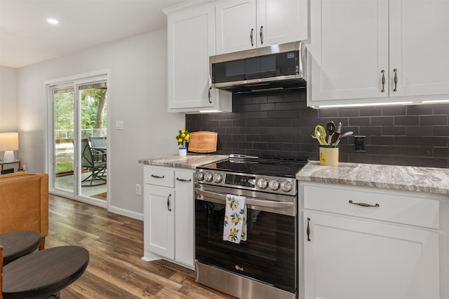 kitchen featuring decorative backsplash, white cabinets, light stone counters, hardwood / wood-style flooring, and stainless steel appliances