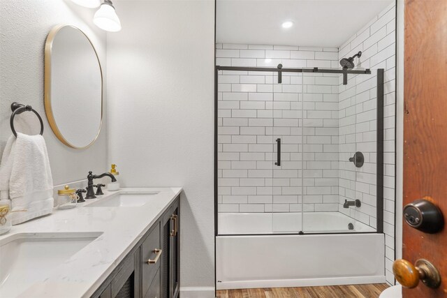 bathroom featuring combined bath / shower with glass door, vanity, and wood-type flooring