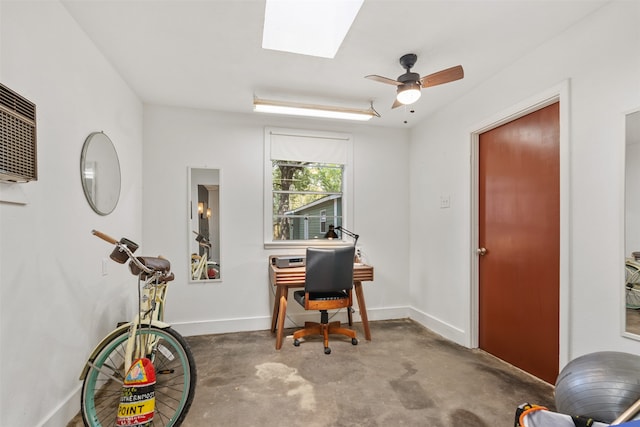 office area featuring ceiling fan, concrete floors, and a skylight