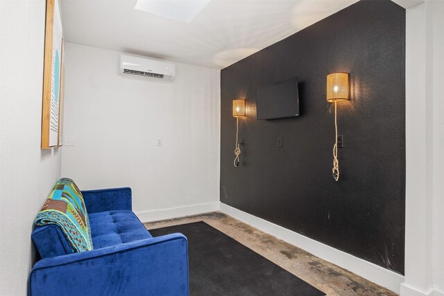 sitting room with a wall unit AC and concrete floors