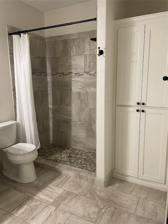 bathroom with tile patterned floors, toilet, and a shower with curtain