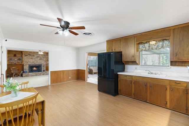 kitchen featuring tasteful backsplash, ceiling fan, crown molding, light hardwood / wood-style flooring, and black oven