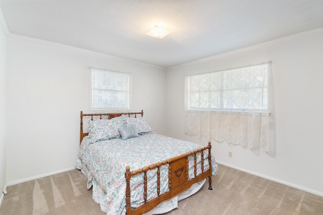 carpeted bedroom with ceiling fan and ornamental molding