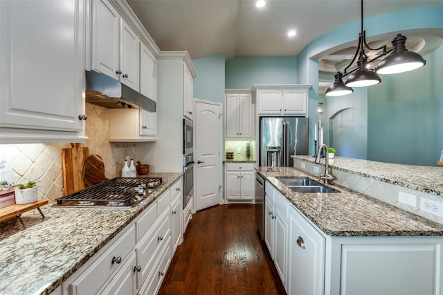 kitchen featuring hanging light fixtures, appliances with stainless steel finishes, white cabinets, a sink, and under cabinet range hood