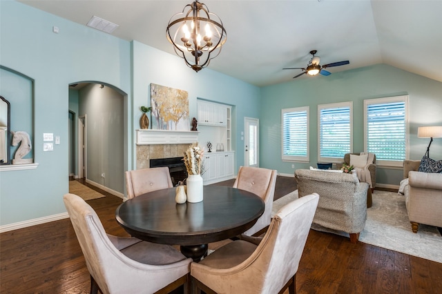 dining room with dark wood-type flooring, a fireplace, visible vents, and baseboards