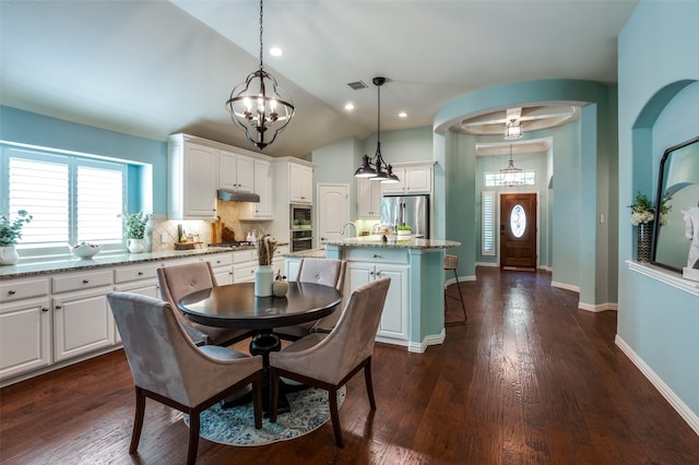 dining room featuring a notable chandelier, dark hardwood / wood-style floors, and vaulted ceiling