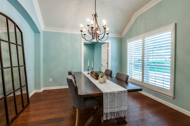 dining space featuring lofted ceiling, dark hardwood / wood-style floors, crown molding, and an inviting chandelier