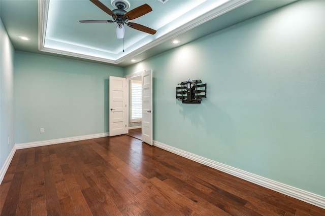 unfurnished room with baseboards, a raised ceiling, a ceiling fan, wood finished floors, and recessed lighting