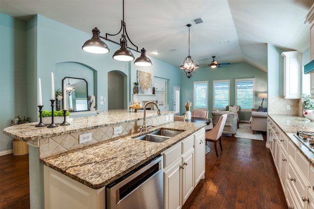 kitchen featuring stainless steel appliances, hanging light fixtures, backsplash, sink, and dark wood-type flooring