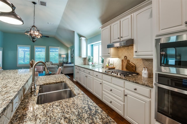 kitchen featuring visible vents, stainless steel appliances, under cabinet range hood, white cabinetry, and a sink