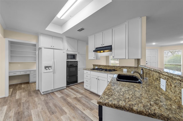 kitchen with sink, appliances with stainless steel finishes, light hardwood / wood-style flooring, and white cabinetry