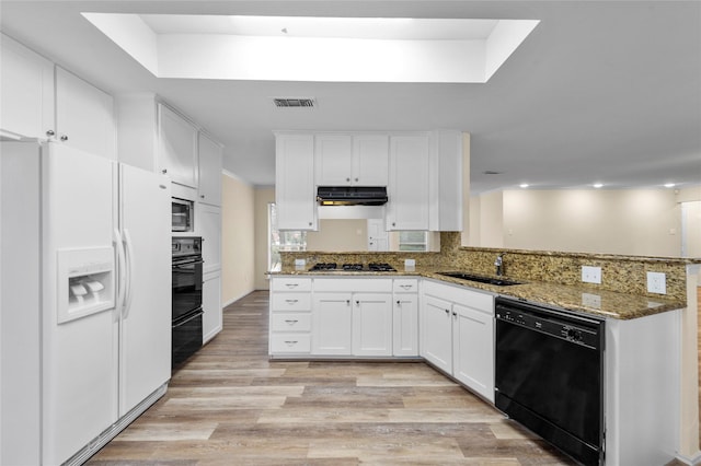 kitchen with a peninsula, black dishwasher, white cabinets, stone counters, and white fridge with ice dispenser