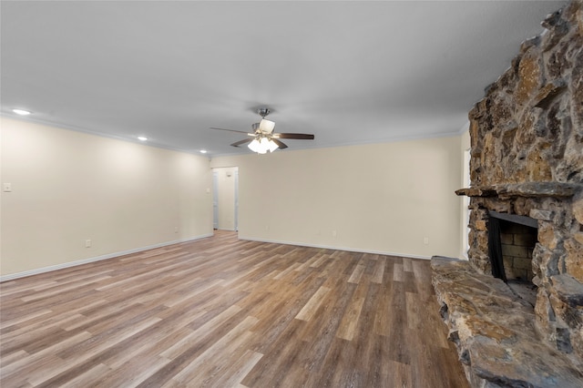 unfurnished living room with light wood-type flooring, a fireplace, and ornamental molding