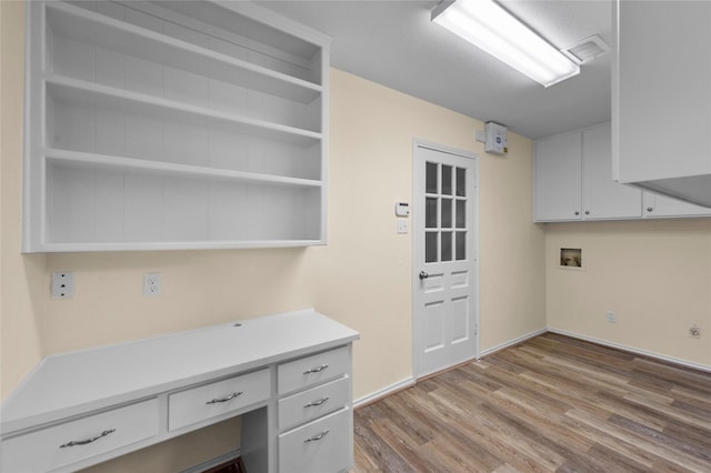 washroom with visible vents, wood finished floors, baseboards, cabinet space, and washer hookup