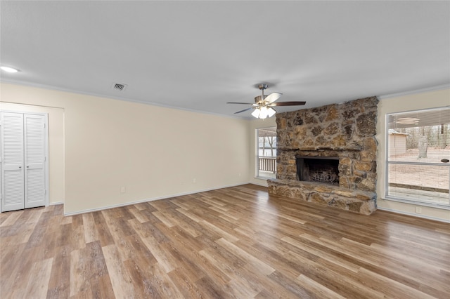 unfurnished living room with ornamental molding, a fireplace, ceiling fan, and light hardwood / wood-style flooring