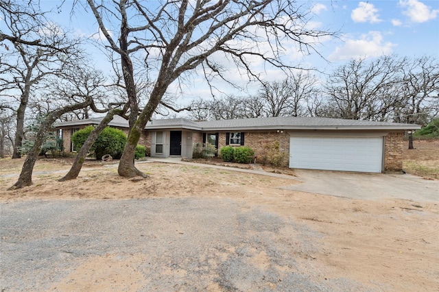 ranch-style home featuring brick siding, an attached garage, and concrete driveway