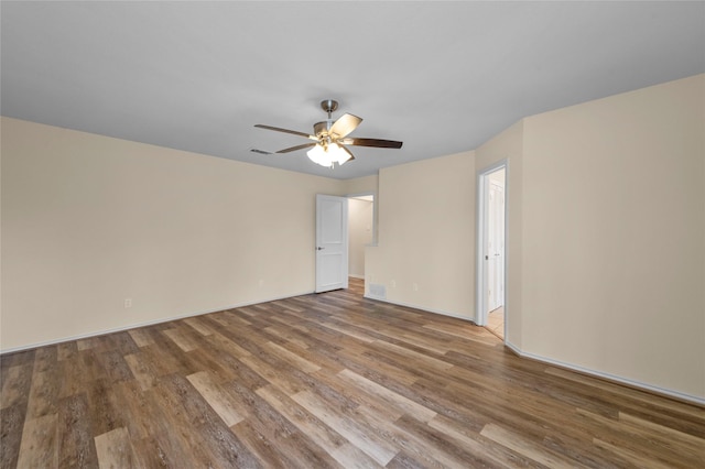 unfurnished room with baseboards, ceiling fan, visible vents, and wood finished floors