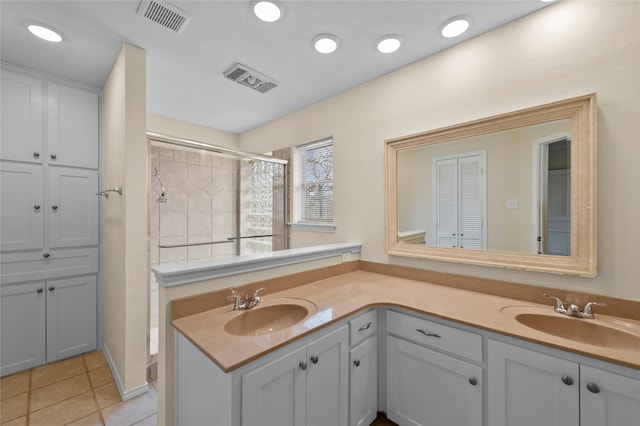 bathroom featuring vanity, a shower with shower door, and tile patterned floors