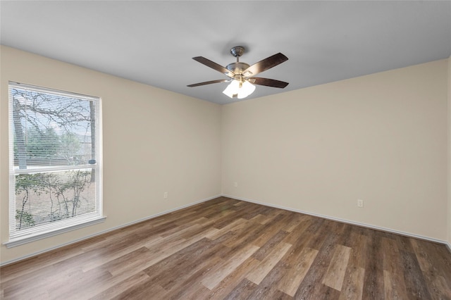 spare room with baseboards, a ceiling fan, and wood finished floors