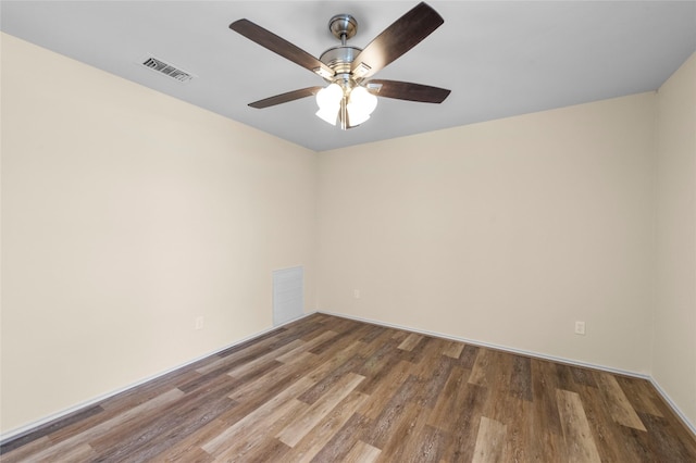 empty room featuring ceiling fan, visible vents, and wood finished floors