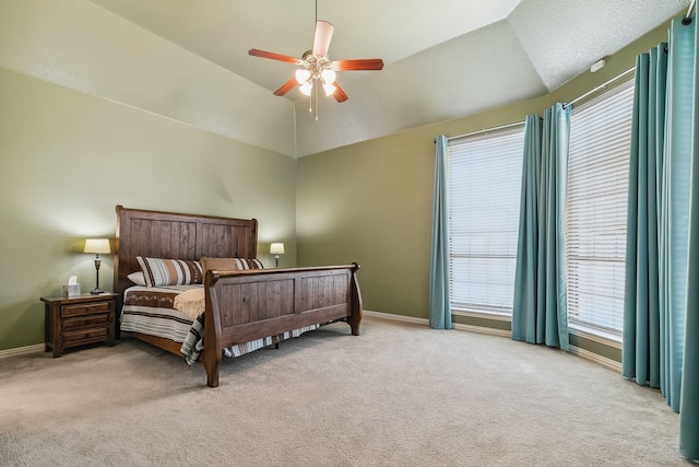 bedroom with ceiling fan, vaulted ceiling, and light colored carpet