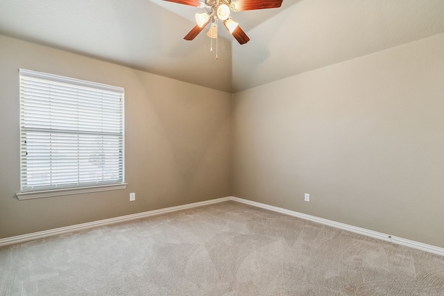 spare room featuring ceiling fan, vaulted ceiling, and light colored carpet