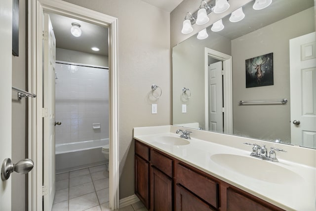 full bathroom featuring double vanity, toilet, tiled shower / bath combo, and tile patterned flooring