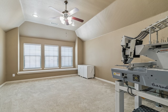 interior space featuring ceiling fan, a textured ceiling, lofted ceiling, and light carpet