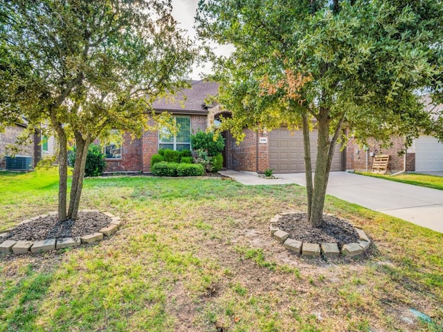 view of property hidden behind natural elements featuring a garage, a front yard, brick siding, and driveway