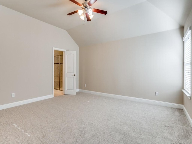 interior space featuring ceiling fan, vaulted ceiling, plenty of natural light, and light carpet