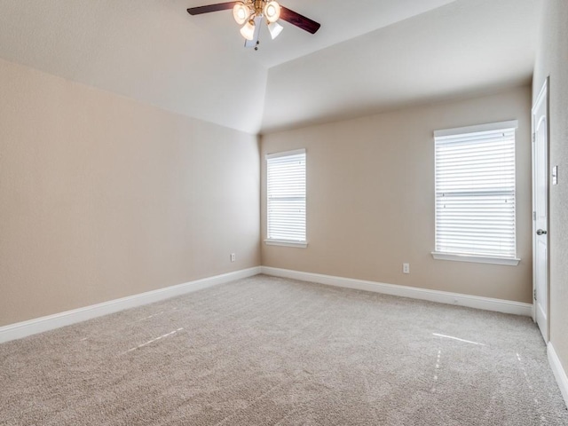 empty room with lofted ceiling, a ceiling fan, baseboards, and light carpet