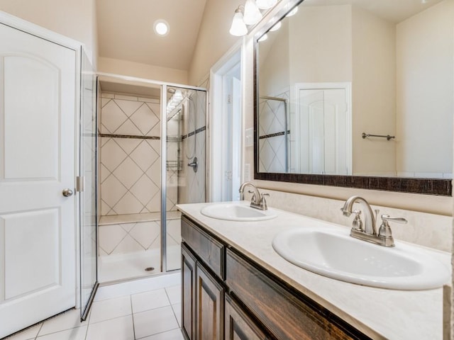 full bath featuring tile patterned floors, a shower stall, double vanity, and a sink