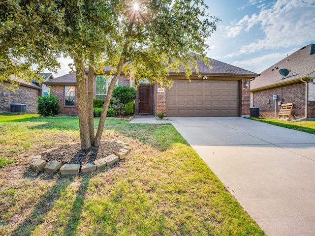 view of front of property with a front yard, a garage, cooling unit, and brick siding