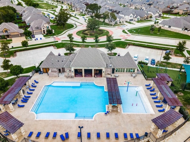 community pool with fence, a patio area, and a residential view