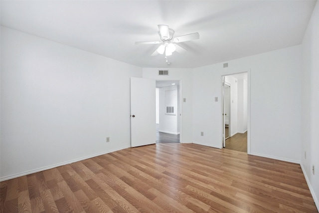 spare room featuring baseboards, visible vents, and light wood finished floors