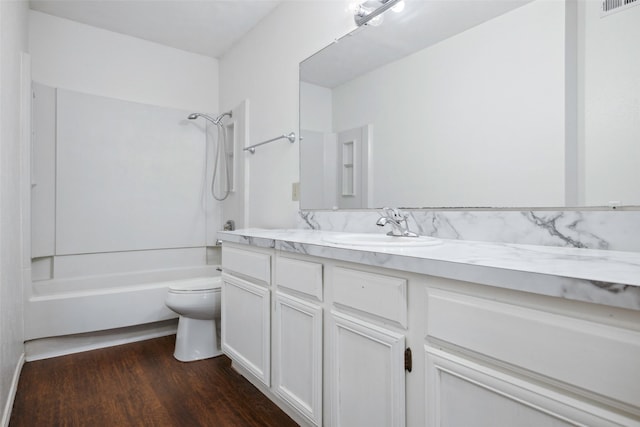 full bathroom featuring hardwood / wood-style floors, vanity, bathing tub / shower combination, and toilet